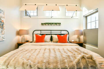 Bedroom with Large Bed, Nightstands, Table Lamps, and Mirror.