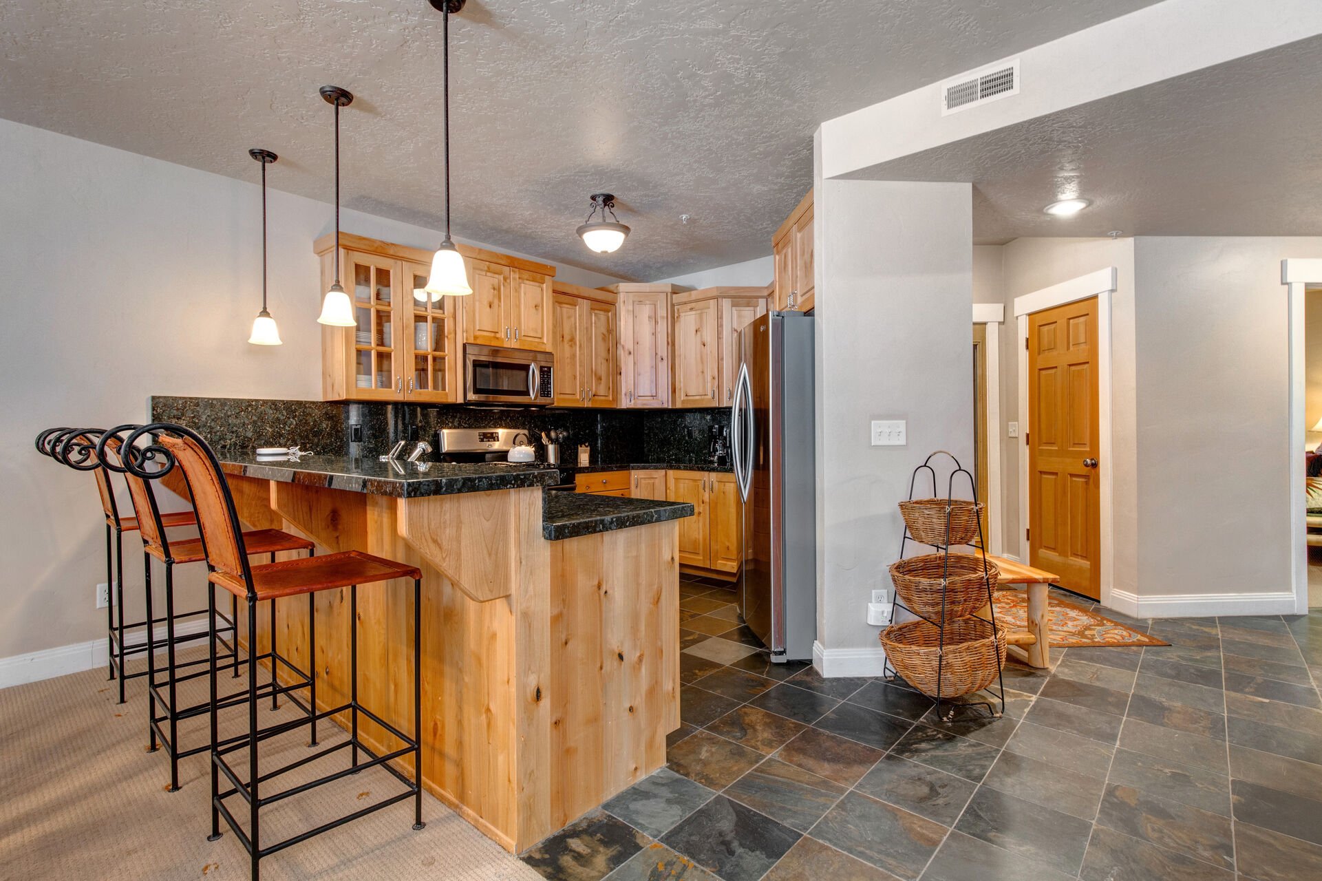 Fully Equipped Kitchen with gorgeous stone countertops, stainless steel LG appliances, built-in ice maker and bar seating for three