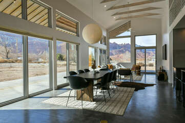 Dining Set, Pendant Lamp, Sofas, TV, and Windows with Mountain Views.