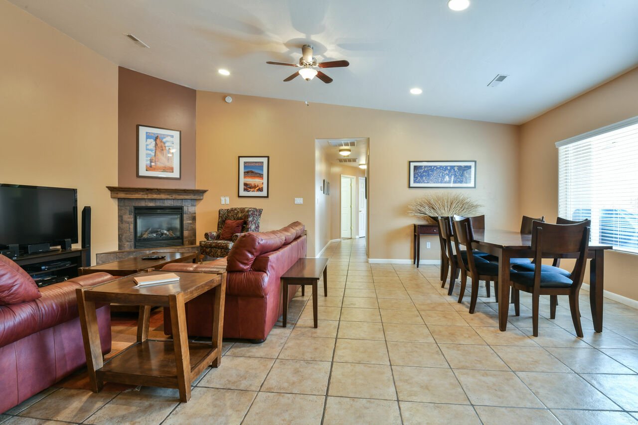 Fireplace, Sofas, Coffee Table, TV, Ceiling Fan, and Dining Set.