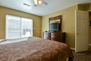 Drawer Dresser, TV, Large Bed and Ceiling Fan.