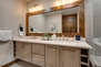 Master Bathroom with dual vanities and over-sized tile shower that has built-in seating and shelving