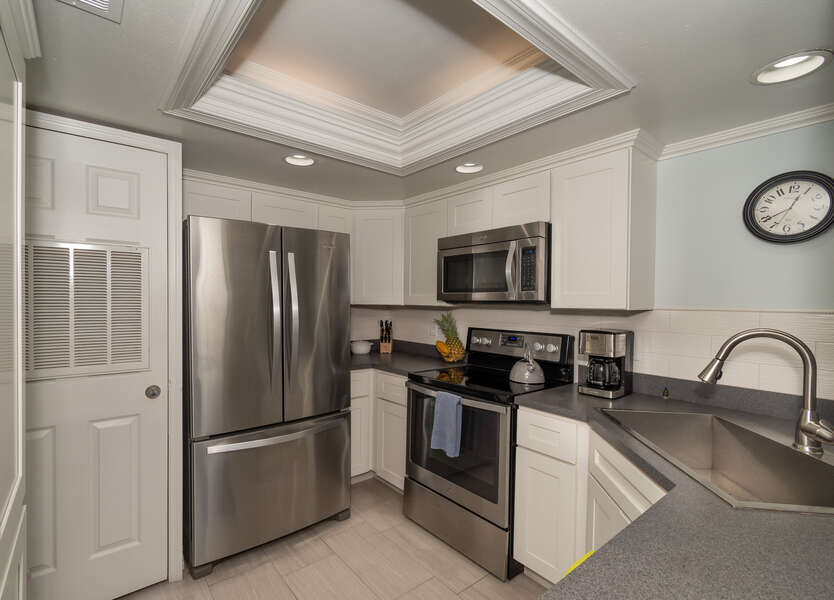 modern kitchen with stainless steel appliances in this new smyrna beach vacation rental