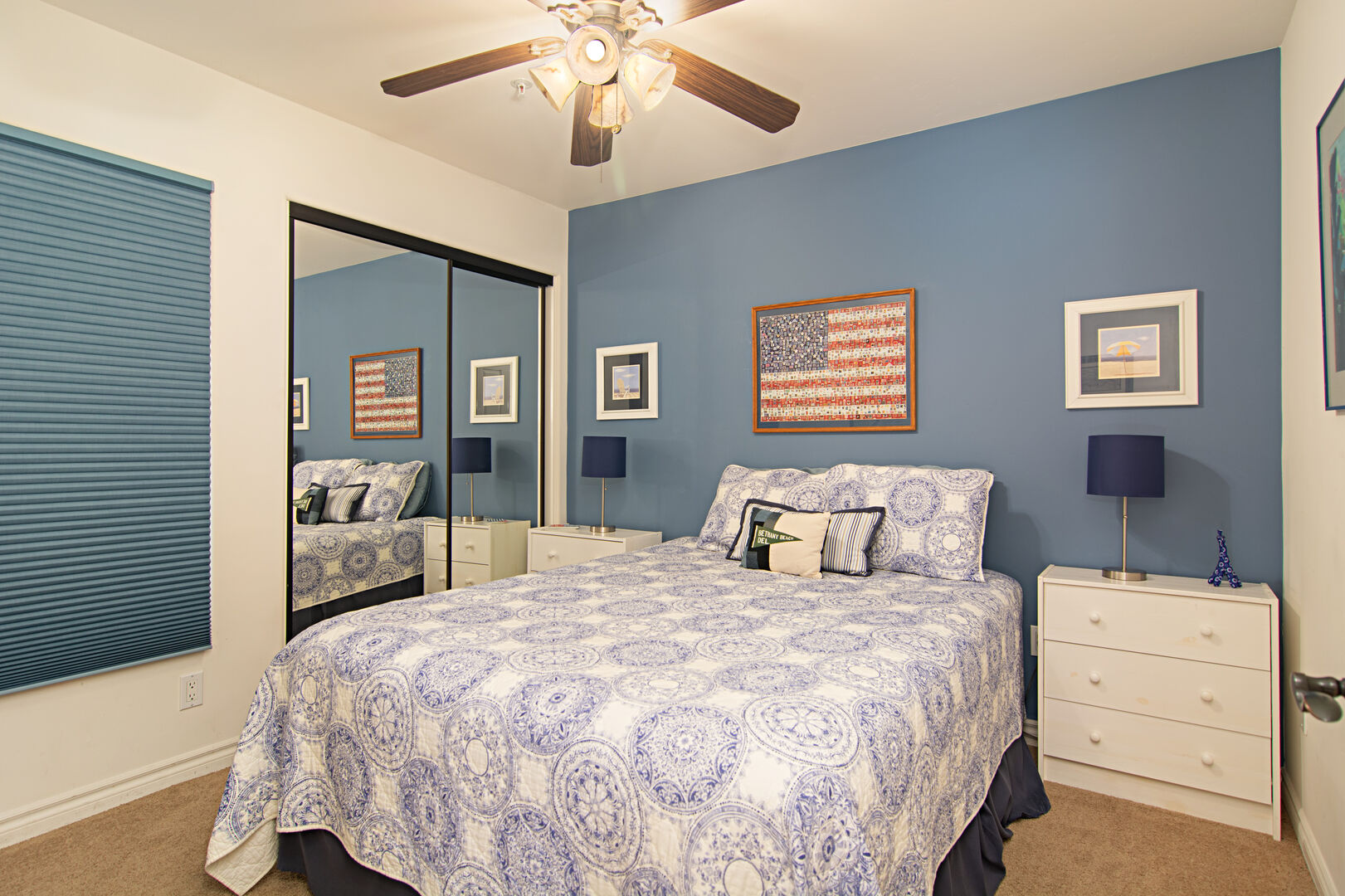 Downstairs guest bedroom with queen bed and ceiling fan