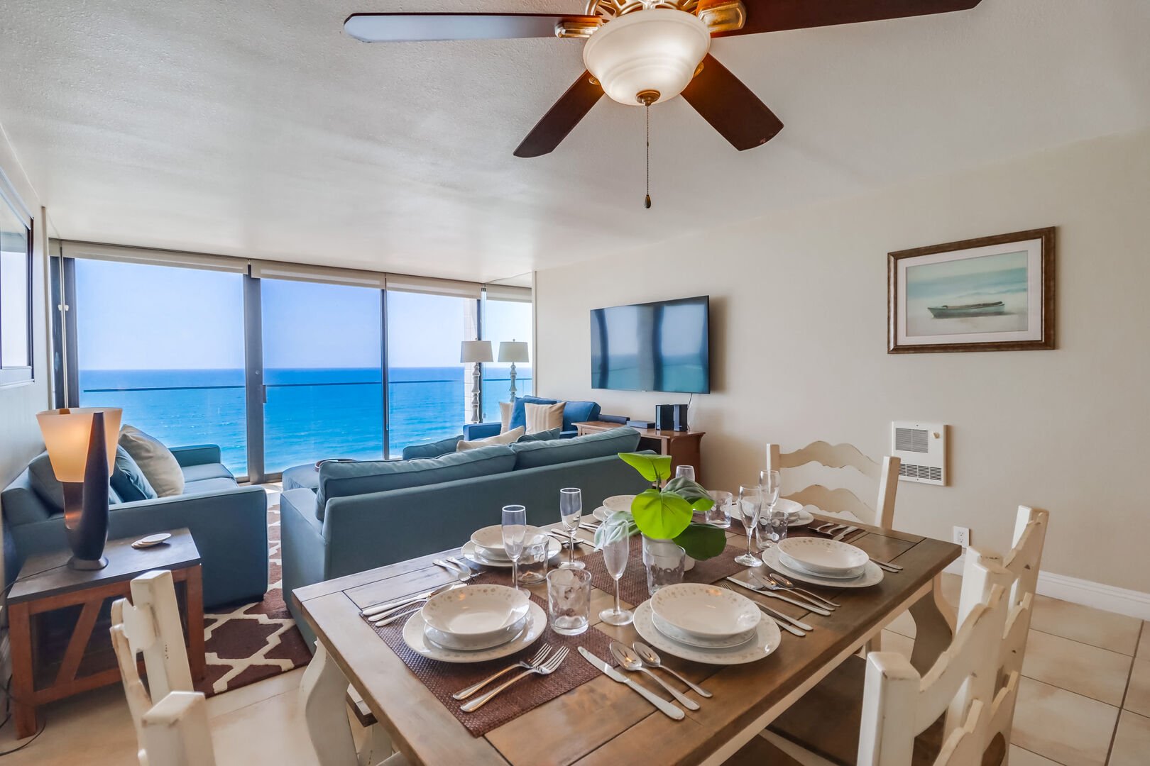Dining table for 6 guests, one side with a long bench. Ceiling fan and ocean views - beach lifestyle in luxury!