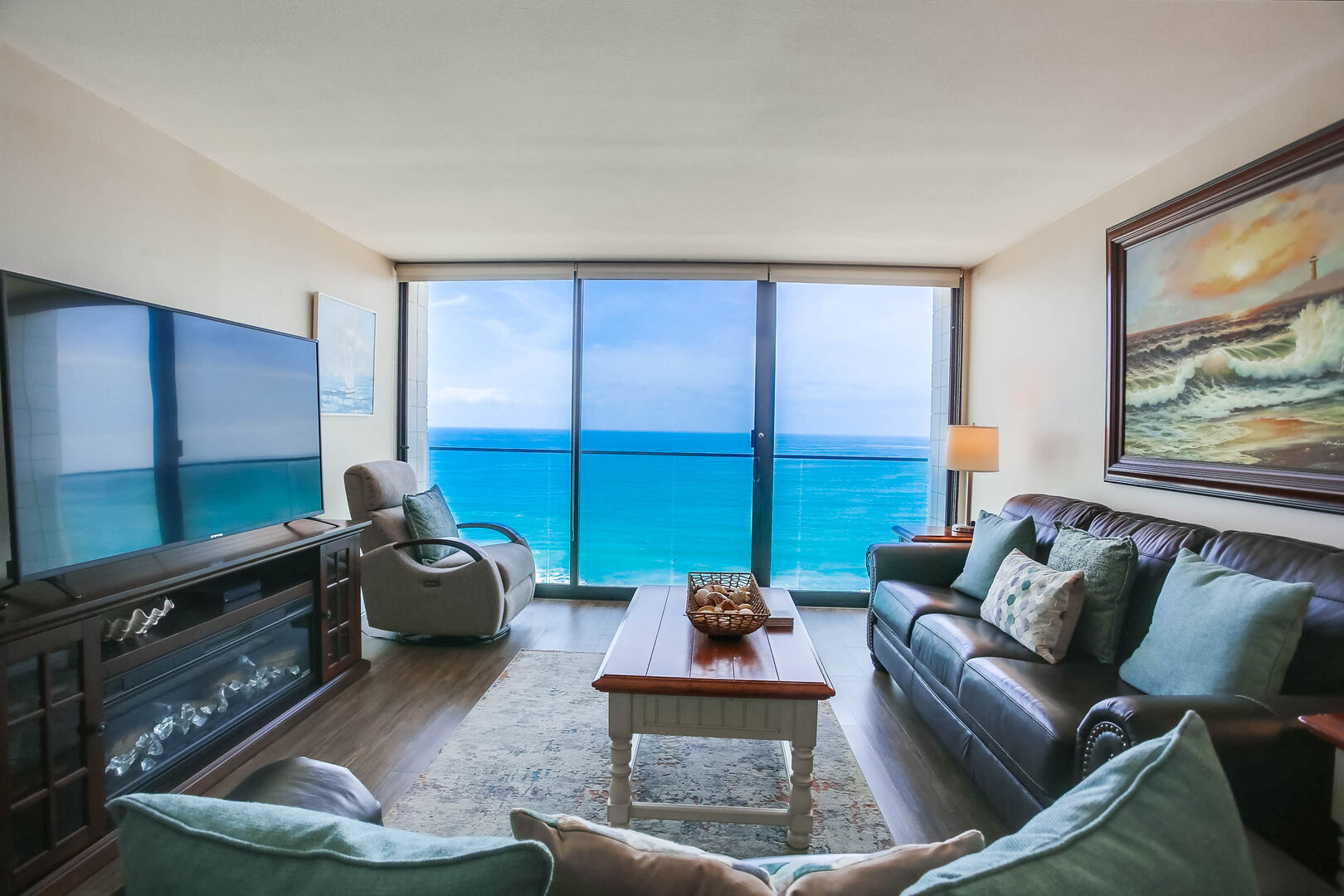 Living room with a queen size sofa bed, TV, recliner and an ocean view