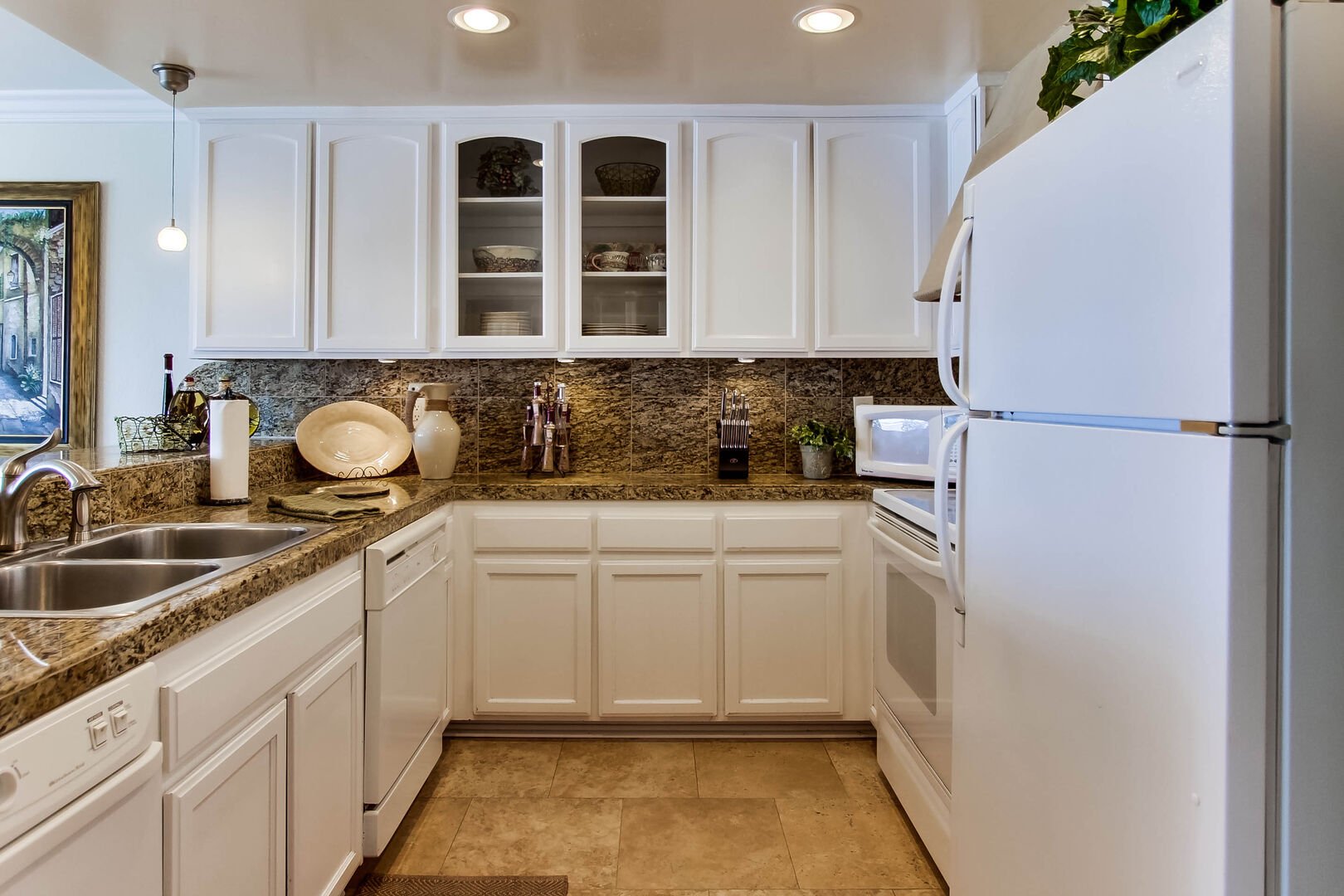 Kitchen with refrigerator, freezer, dishwasher, stove, oven, microwave, wine refrigerator, stainless steel appliances, quartz countertops and ample cabinet and drawer space