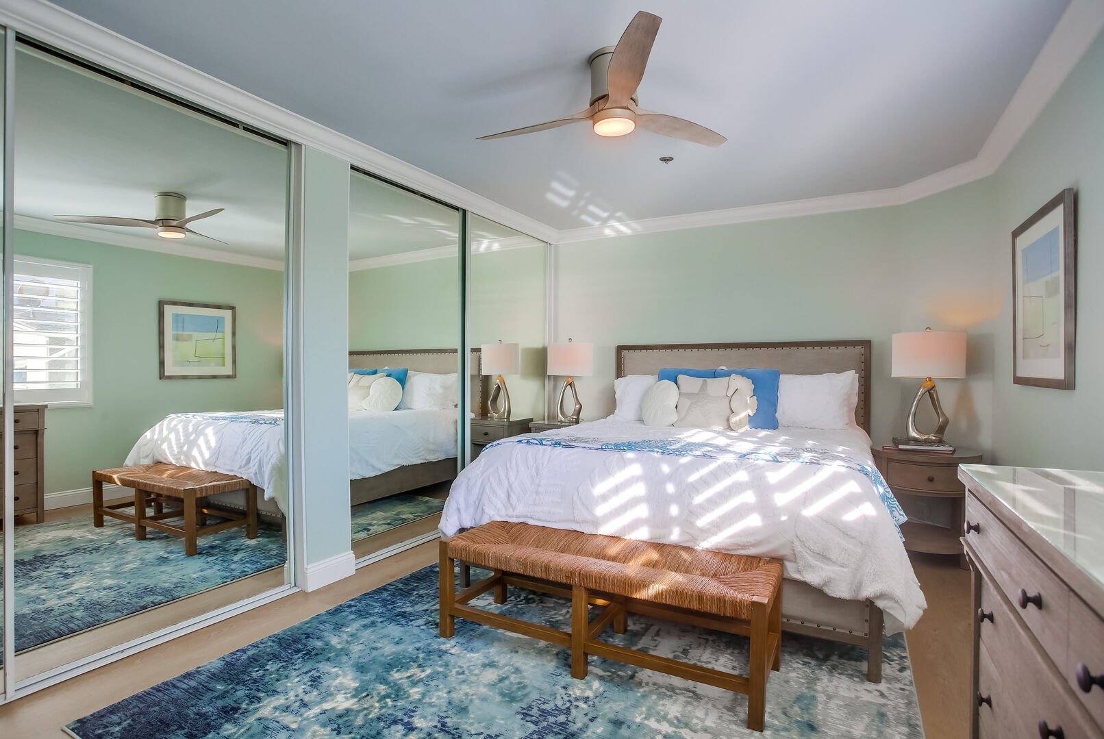 Renovated master bedroom with king bed, mirrored closets, overhead lighting and remote-control fan, new floors, furniture and decor! In-suite/shared bathroom as well