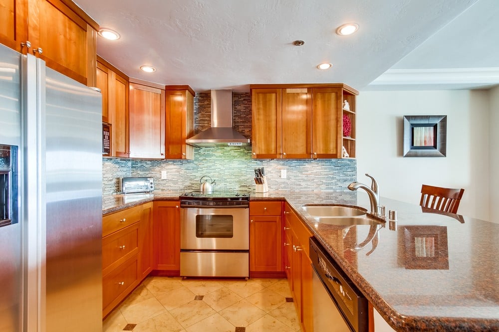 Open kitchen fully equipped for meals at home with granite countertops and recessed lighting