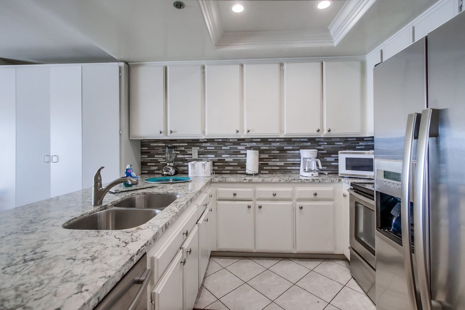 Kitchen with stainless steel appliances, dishwasher, refrigerator, freezer, stove, oven, microwave, sink and ample cabinet and drawer space