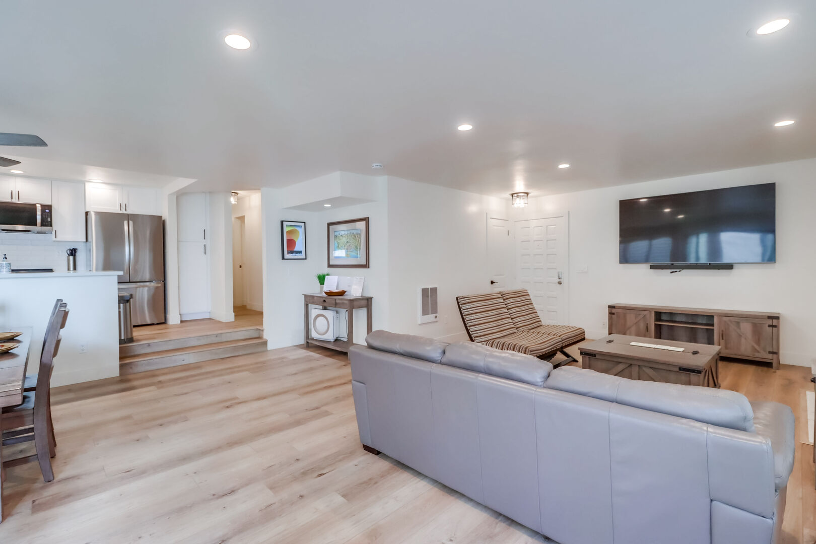 Open floor plan with new flooring, furniture, and overhead lighting!