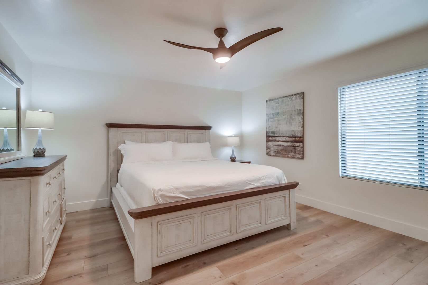 Master bedroom with king bed, ceiling fan, dresser, smart TV, walk-in closet and in-suite full bathroom