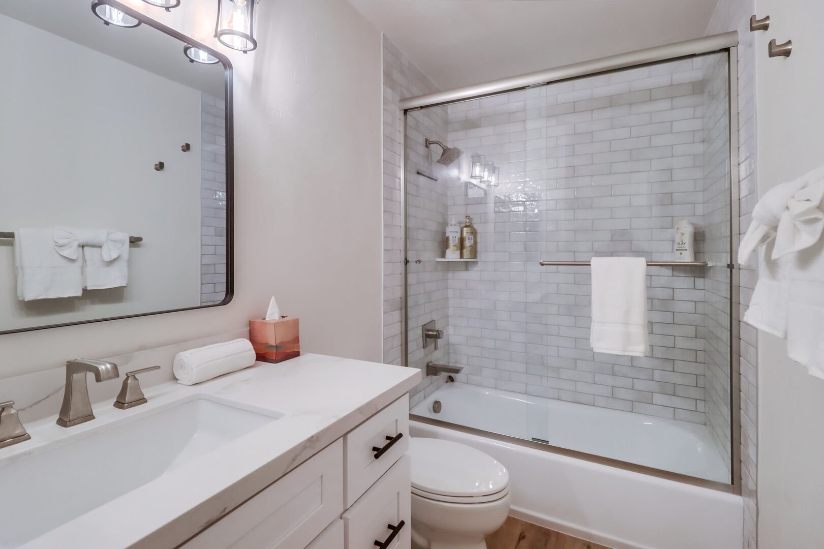 BRAND NEW! Located between guest bedrooms, vanity with beautiful lighting and shower-tub combo