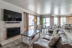 Living room with comfortable seating, TV with Cable, gas fireplace and plenty of natural light