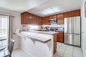 Open kitchen fully equipped with refrigerator, freezer, oven, stove, microwave, dishwasher, sink and ample storage space
