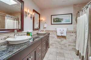 Master in-suite bathroom with new lighting fixtures, large sinks, long vanity and ample storage