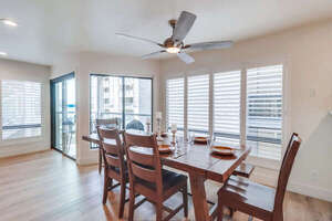 Dining table for 6 with ceiling fan and entrance to covered patio with corner views of the bay!