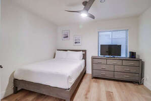 Second guest bedroom - first bedroom when entering from the living space. Queen bed, ceiling fan, dresser and Smart TV