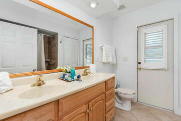 GUEST BATHROOM
(hallway bath with combo tub shower, double vanity sink, pool area access)