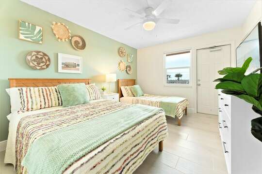 Guest bedroom with one full bed and one twin bed, TV & closet (not, this room is not oceanfront)