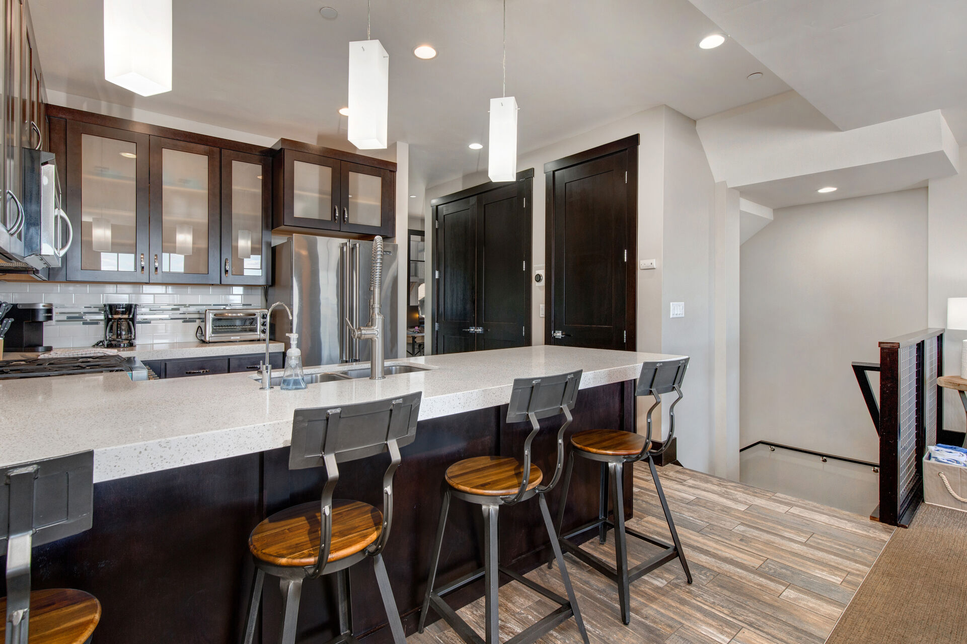 Main Level Fully Equipped Kitchen with beautiful stone countertops, stainless steel Viking appliances, and bar seating for four