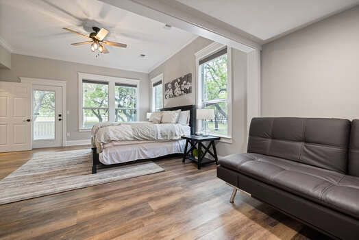 Master bedroom with a king bed, full-size futon, plenty of windows and natural light, and exterior access