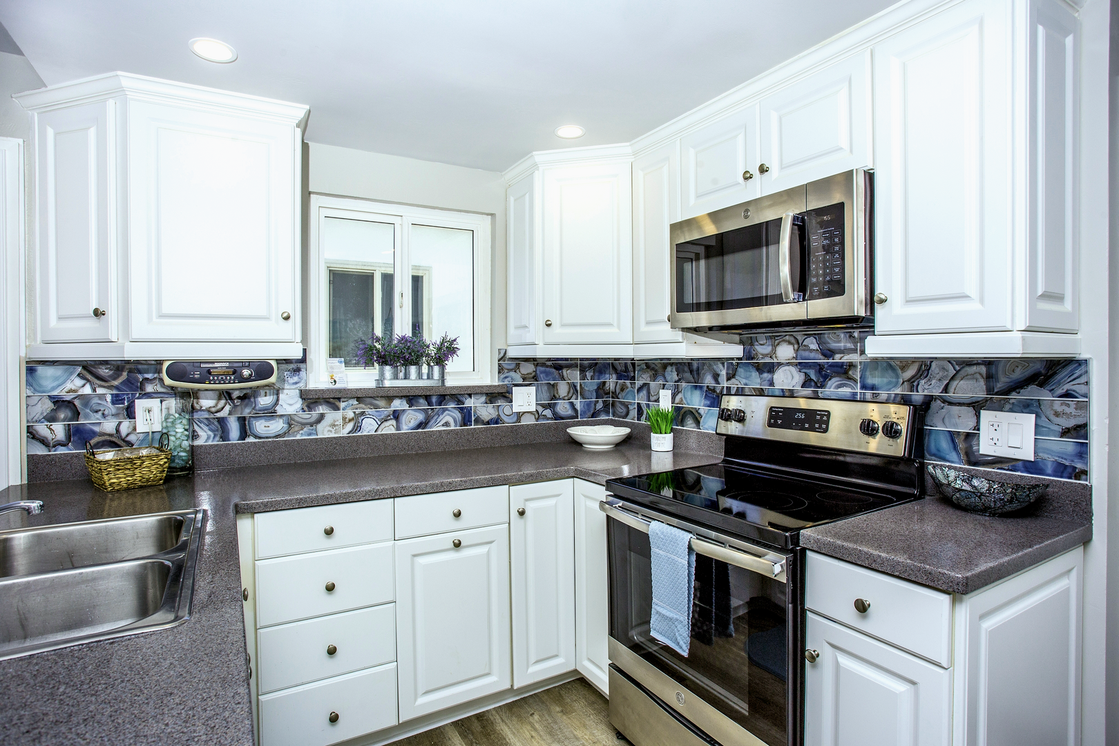 Newly remodeled kitchen with stainless steel appliances, sink, toaster, blender, coffee maker