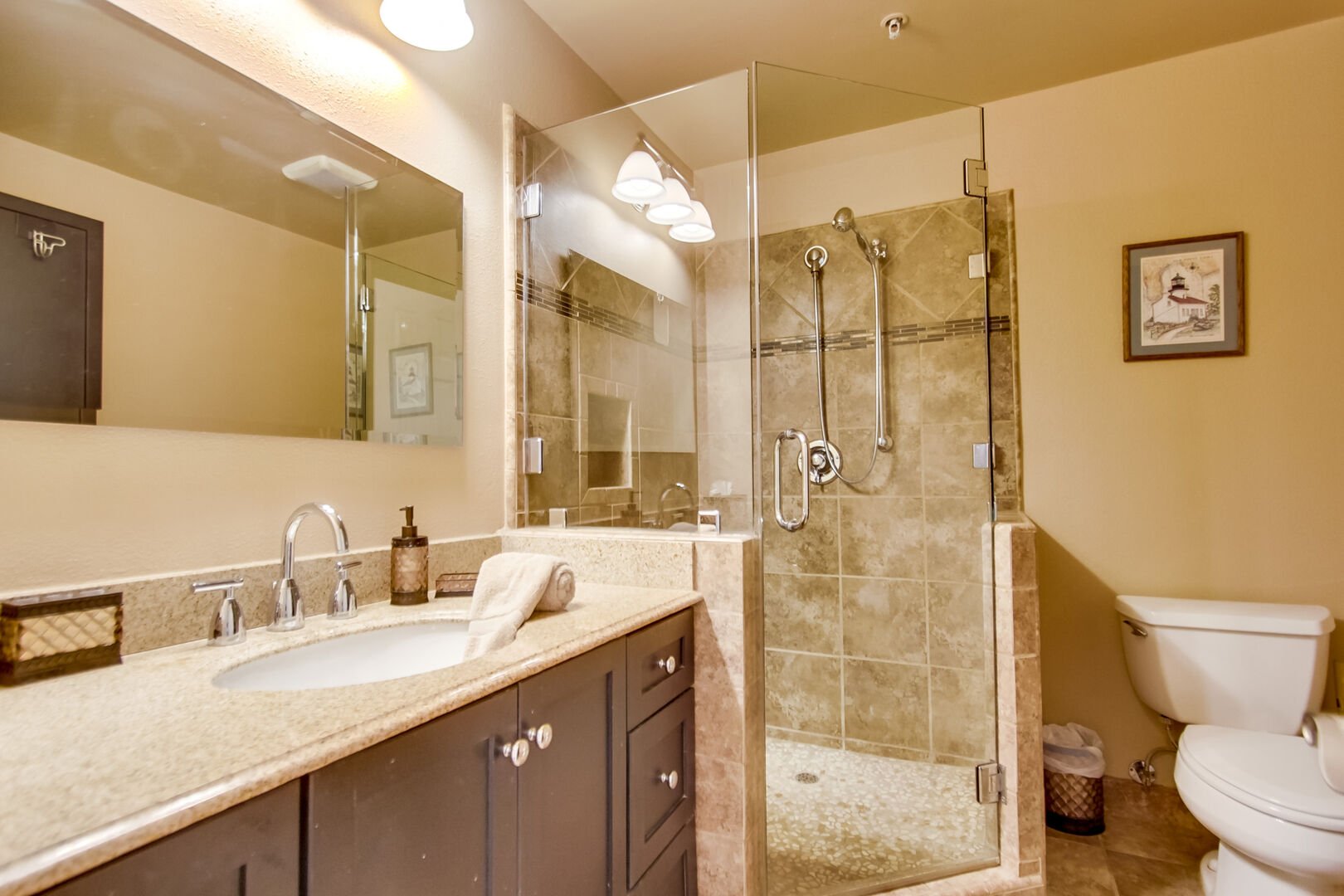 Bathroom with shower, vanity sink, mirror and overhead lighting