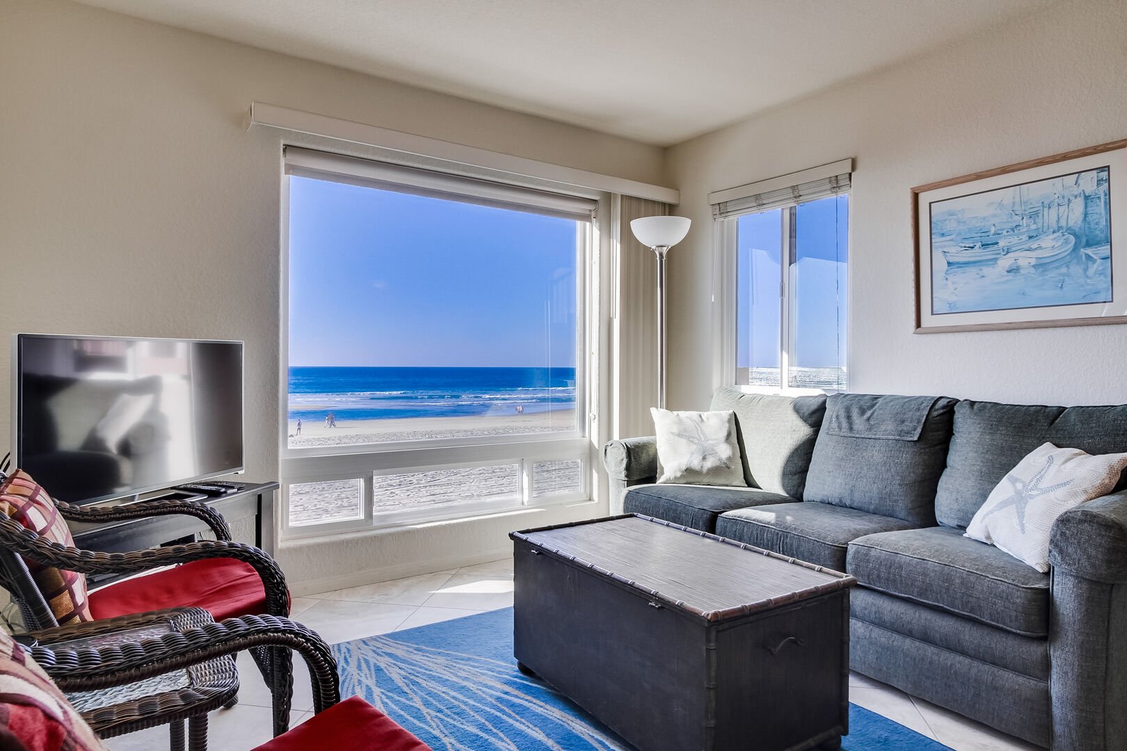 Living room with queen sofa bed, TV, lamp, lots of light, and incredible views of Pacific Beach and boardwalk