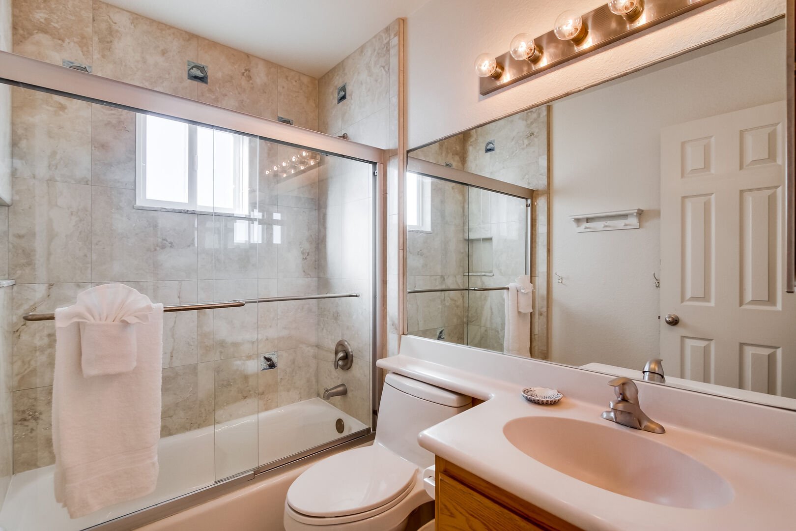 Bathroom with vanity sink, mirror, toilet and shower/ tub combination