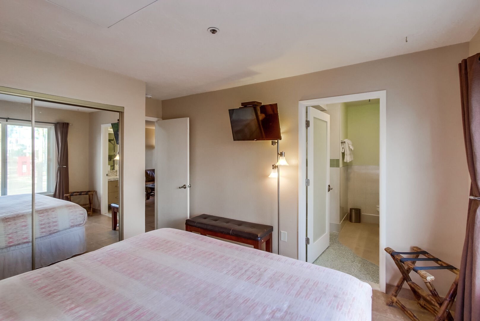 Guest or master bedroom with king size bed, mirrored closet with ample storage space, TV, and in-suite full bathroom