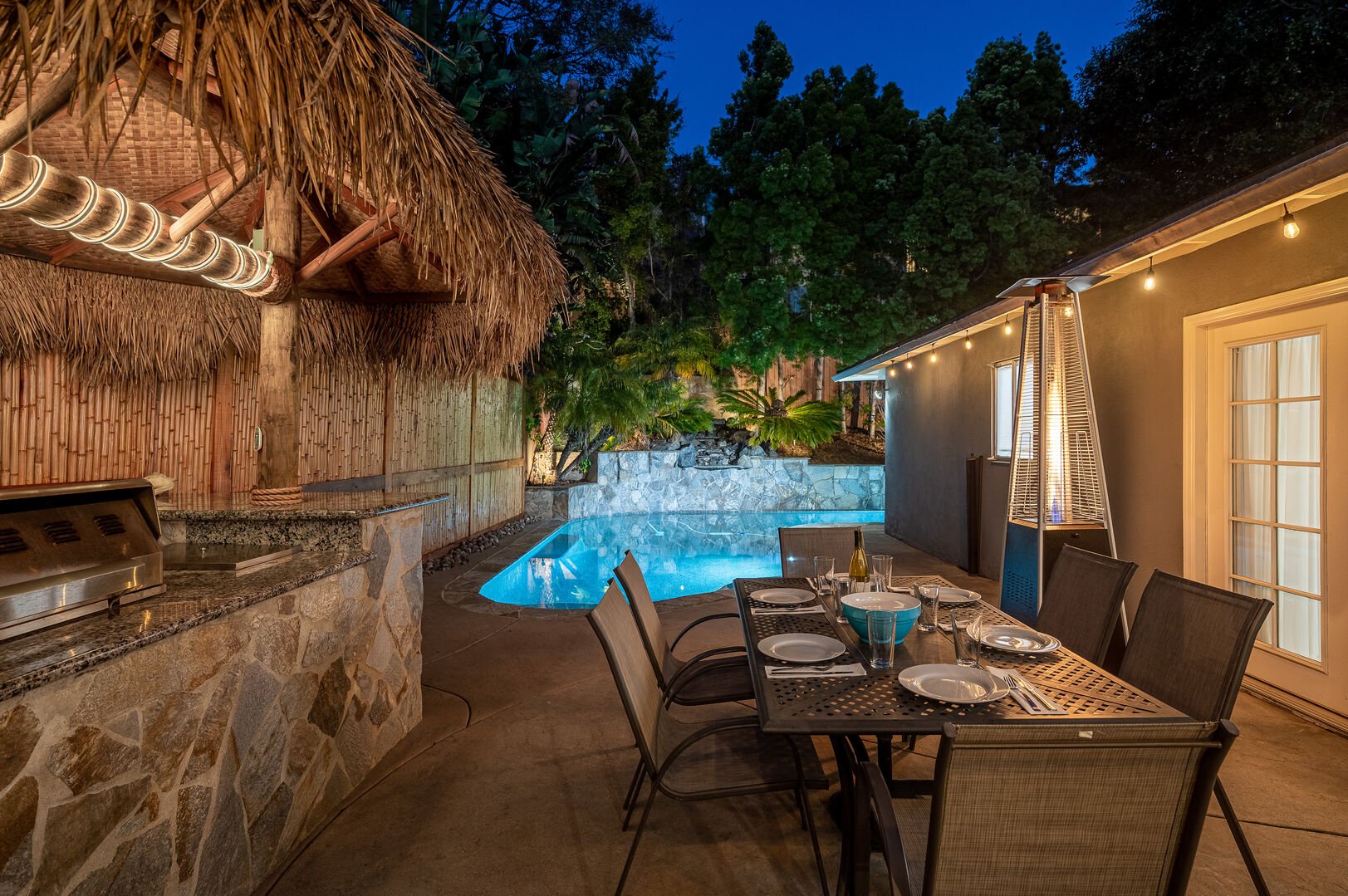 The large outdoor patio and pool area is an oasis complete with fire pit, jacuzzi, and wood cabana with lounge seating