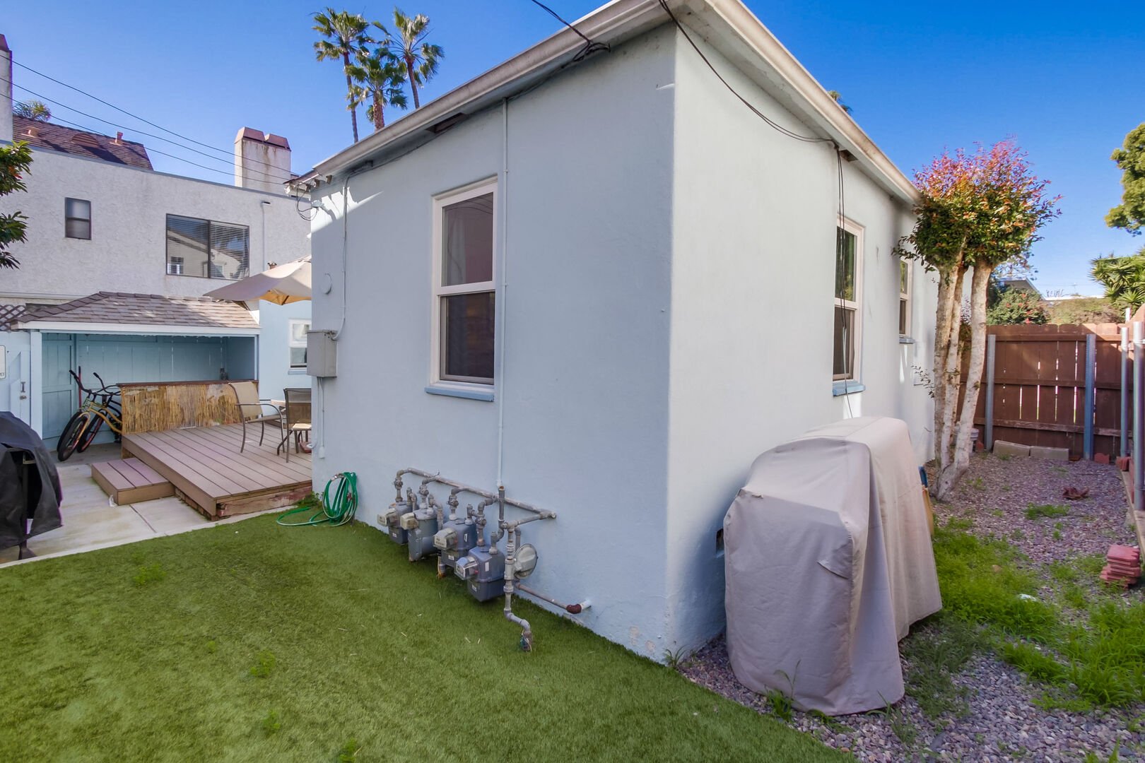 Side patio yard with BBQ, fully enclosed and welcome to furry friends!