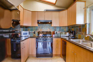Kitchen with oven, refrigerator, sky light, sink toaster, stove, oven, microwave, coffee maker, blender
