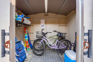 Outdoor storage closet with beach accessories: bikes, umbrella, beach chairs, cooler, beach toys