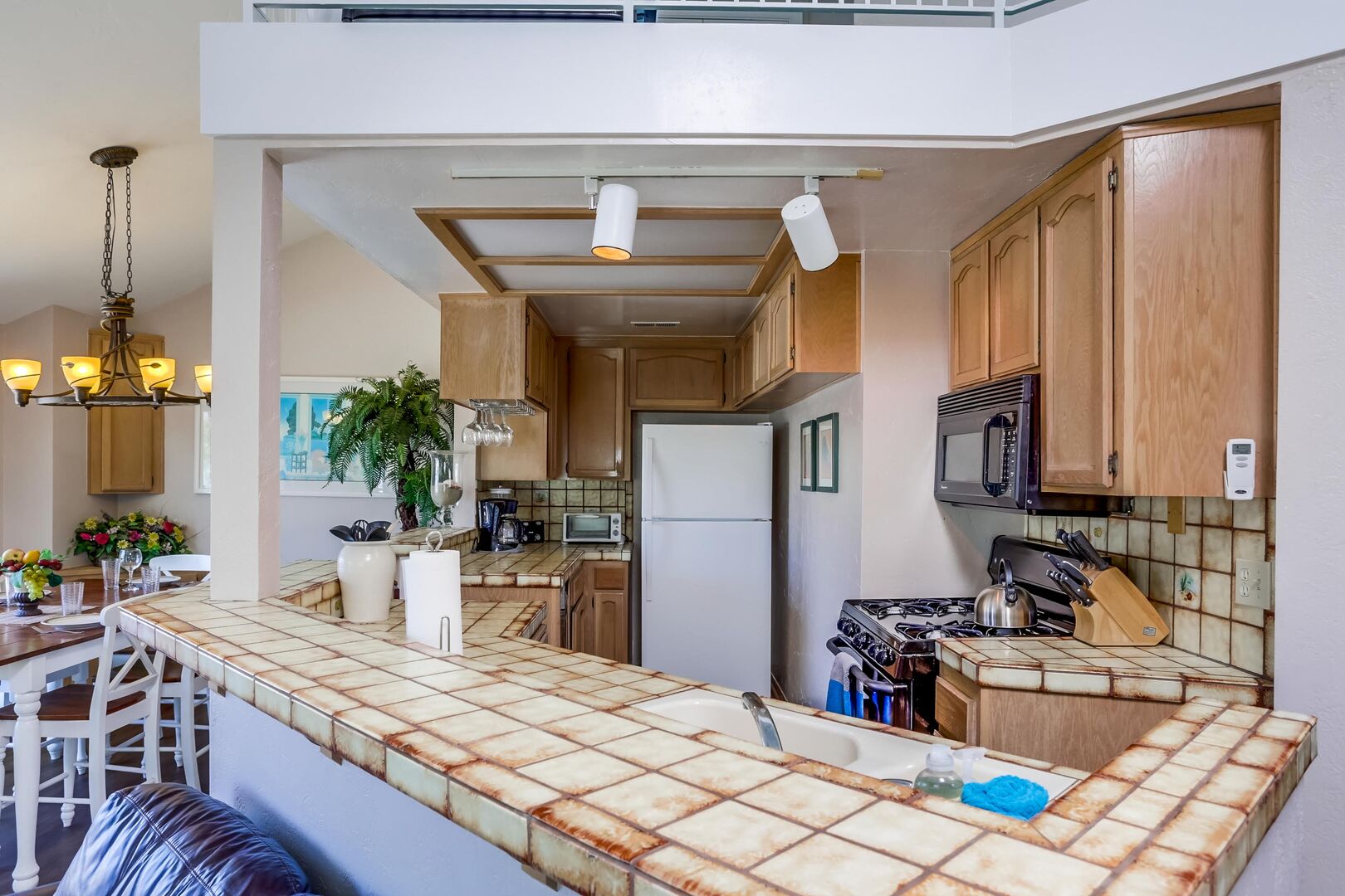 Kitchen with refrigerator, toaster, microwave, overhead lighting, sink, blender