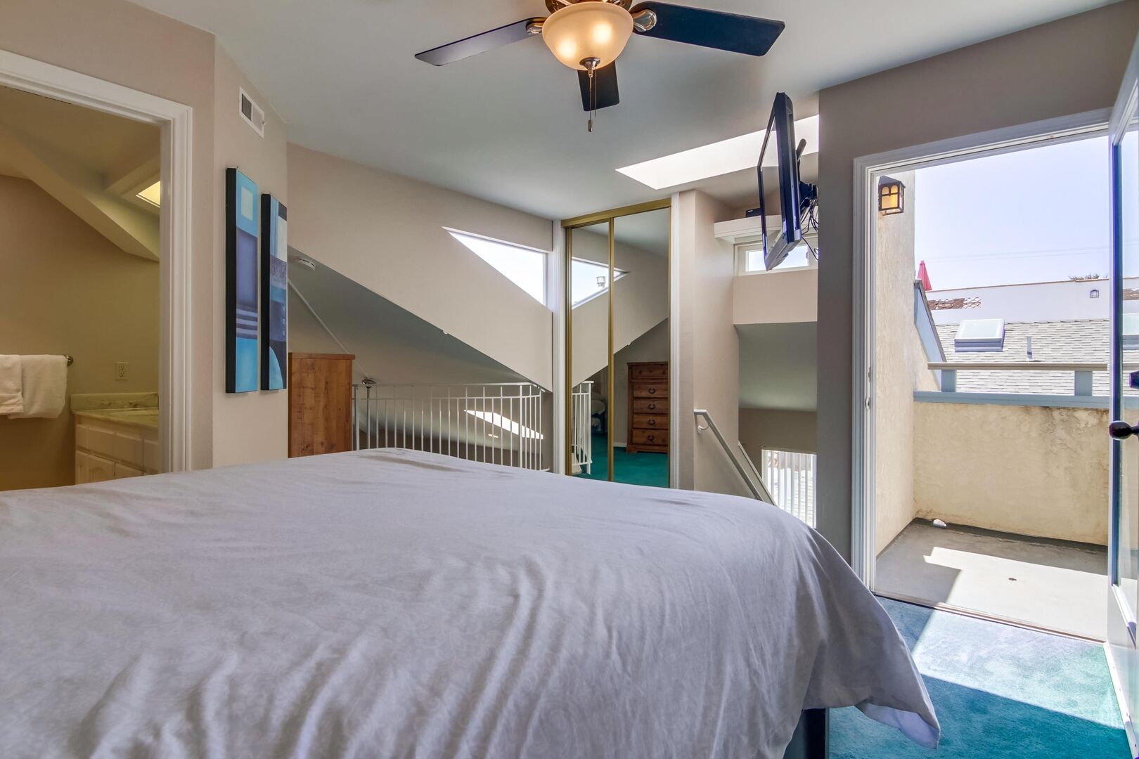 Upstairs loft with small balcony, queen size bed, bathroom, TV, ceiling fan