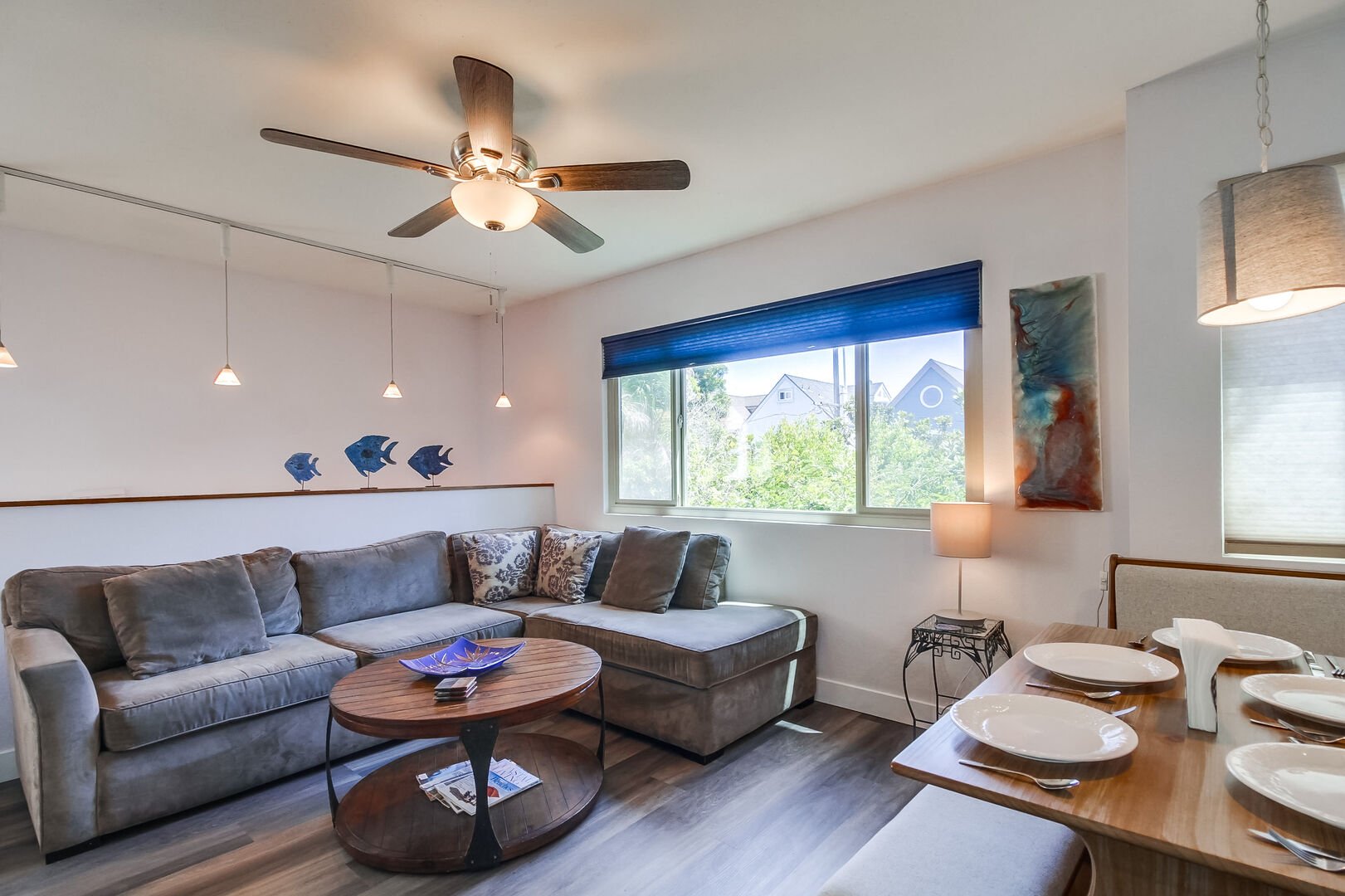 Ascend up a short flight of stairs to the living room with recessed lighting, ceiling fan, TV and queen sofa bed. Open living space with lots of natural light