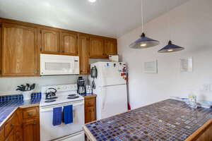 Fully equipped kitchen with stove, oven, refrigerator, freezer, standard coffee maker, pantry storage and breakfast bar