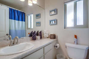 Upstairs shared guest full bathroom with large vanity, toilet and shower-tub combination