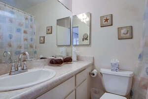 In-suite full guest bathroom connected to the lower level bedroom with large vanity, toilet and shower-tub combo