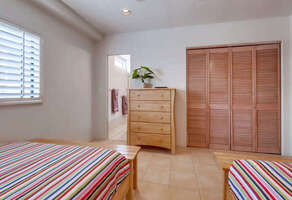 Guest bedroom has en-suite full bathroom, dresser and closet storage