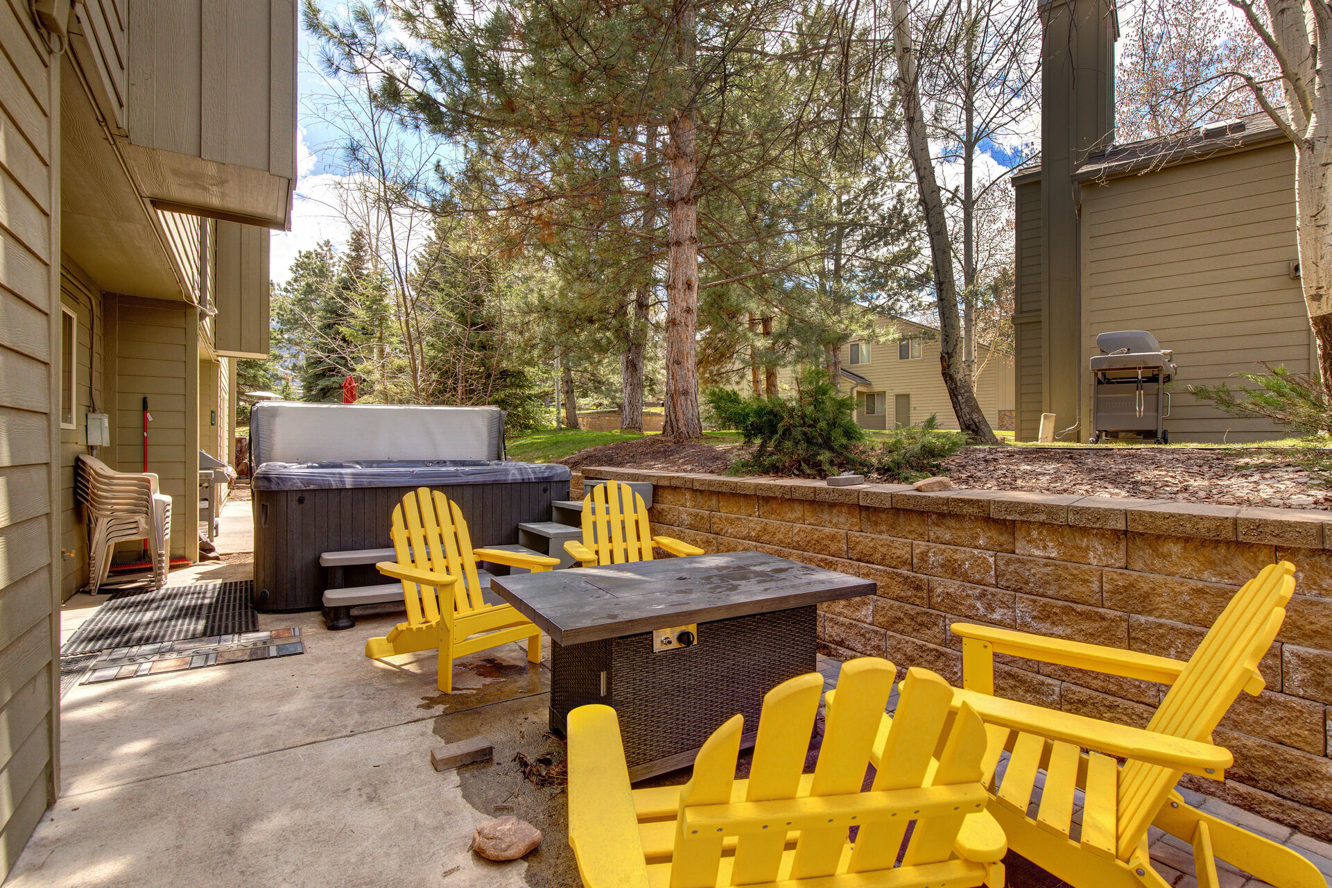 Private back patio with hot tub, seating for four, fire pit, and BBQ grill