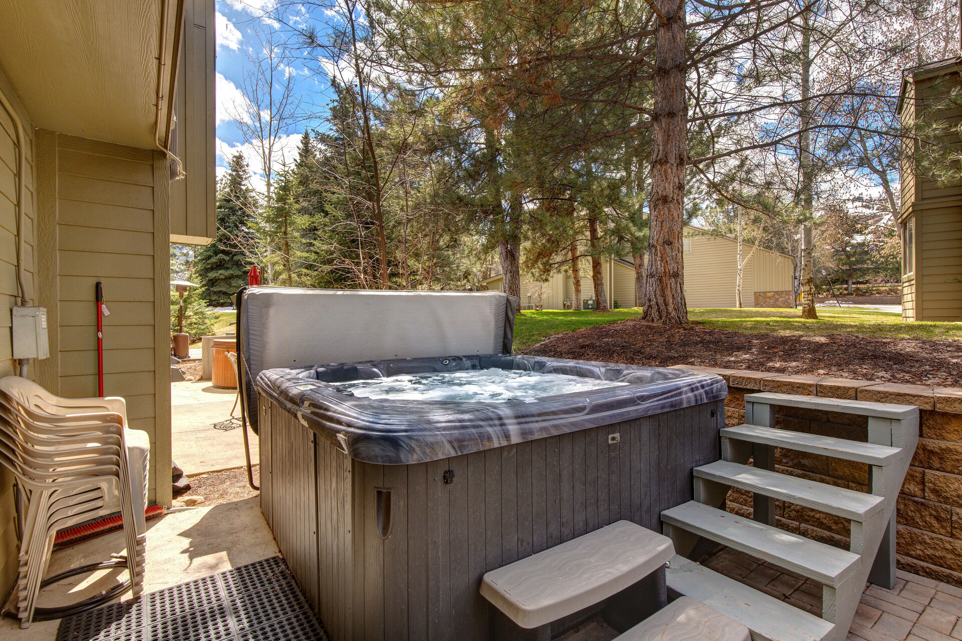 Private back patio with hot tub, seating for four, fire pit, and BBQ grill