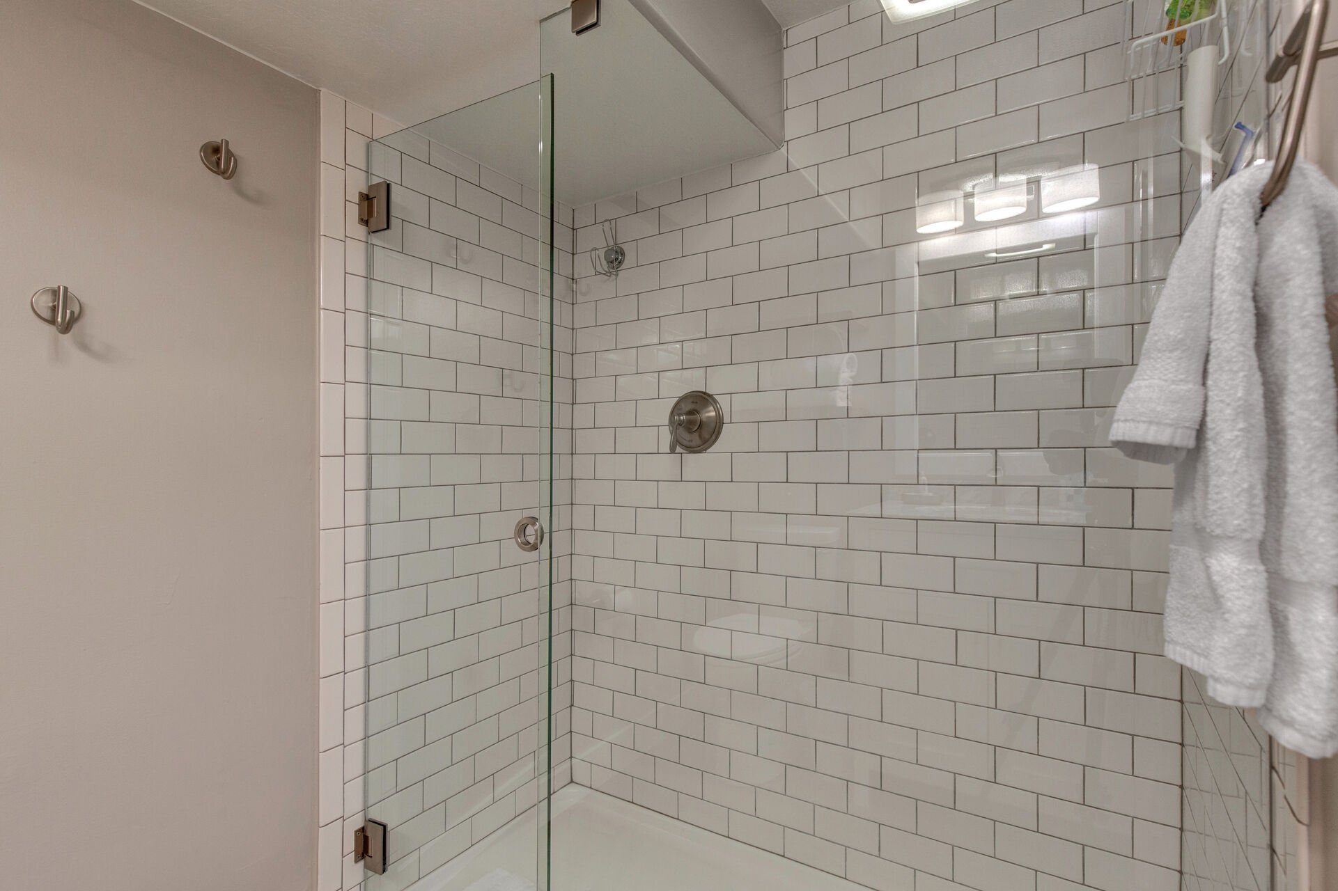 Main Level shared full bathroom with large tiled shower