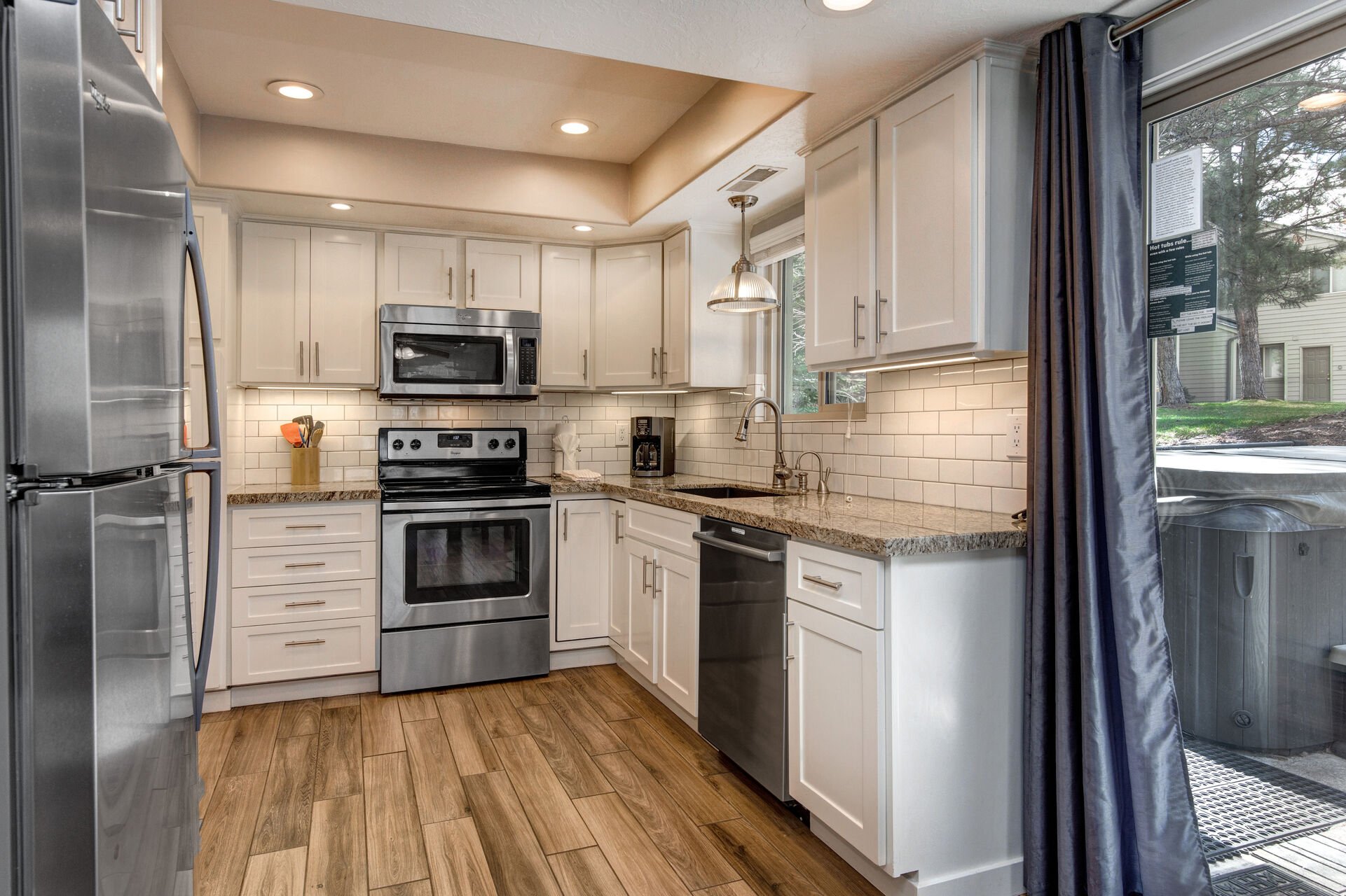 Fully Equipped Kitchen with stone countertops, stainless steel whirlpool appliances, and private patio access