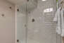 Main Level shared full bathroom with large tiled shower