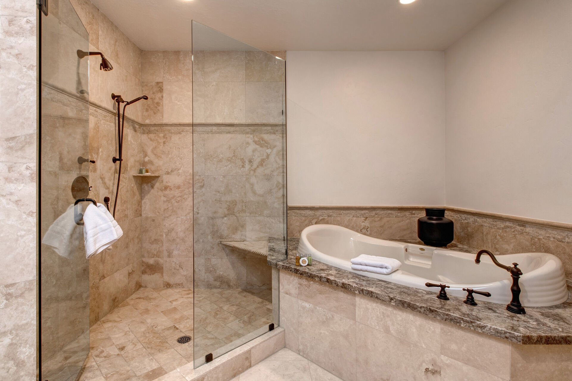 Main Level Grand Master bathroom with two granite vanities, large jetted soaking tub, and oversized tile shower