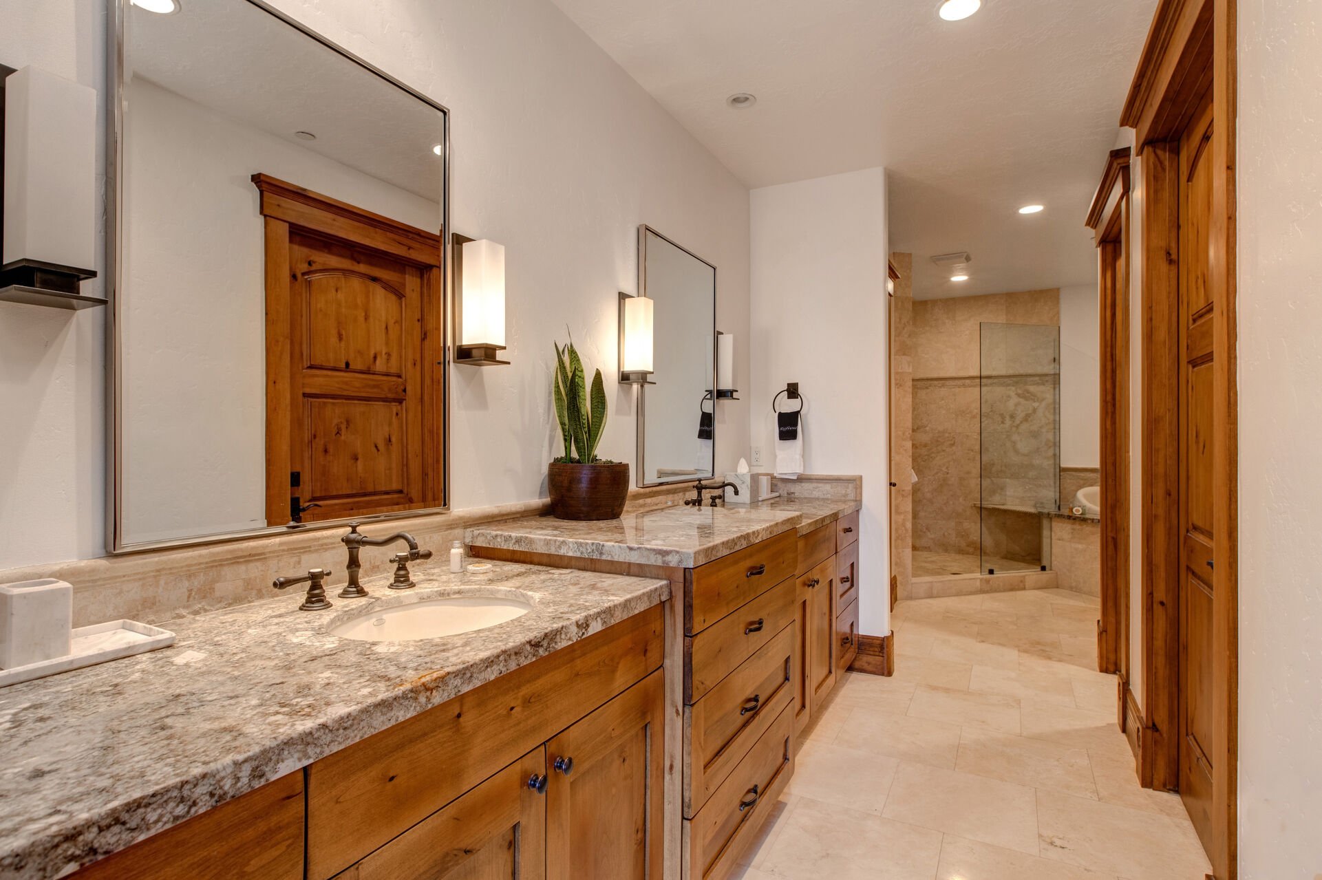 Main Level Grand Master bathroom with two granite vanities, large jetted soaking tub, and oversized tile shower