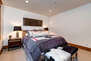 Upper Level Bedroom 3 with king bed, hot tub patio access, and en suite bathroom
